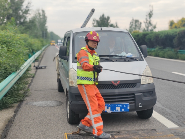 亳州中心阜陽段上行K376施救員徐建才調(diào)整拖車鋼絲繩，開展救援行動。.jpg